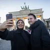 Zwei Workshop-Teilnehmer machen ein Selfie vorm Brandenburger Tor